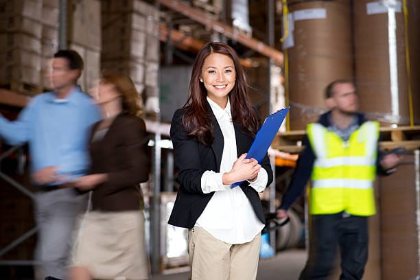 confident businesswoman in busy warehouse